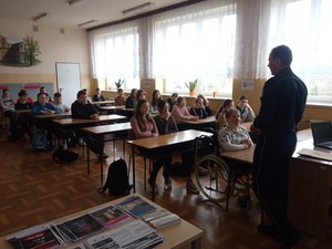 Policjant prowadzący zajęcia z uczniami w ramach działań profilaktycznych