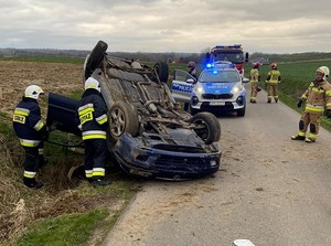 Miejsce zdarzenia drogowego straż pożarna, policja oraz samochód marki Mazda