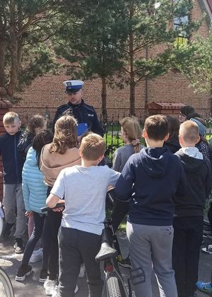 Policjanci prowadzą prelekcję z dziećmi przed egzaminem na kartę rowerową