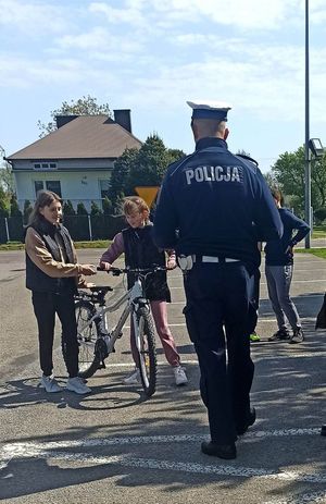 Policjanci przeprowadzają egzamin praktyczny dla dzieci zdające na kartę rowerową