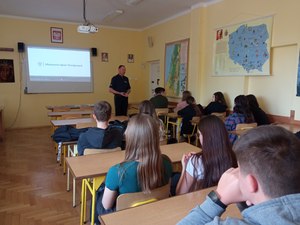 Policjant prowadzi zajęcia z młodzieżą w liceum, dotyczące Handlu Ludźmi