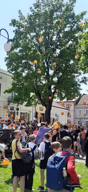 Dzieci podczas marszu przeciwko przemocy trzymają w dłoni pomarańczowe baloniki