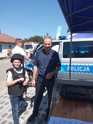 Przeworscy policjanci na pikniku rodzinnym w Kańczudze pokazują dzieciom radiowóz orz sprzęt policyjny