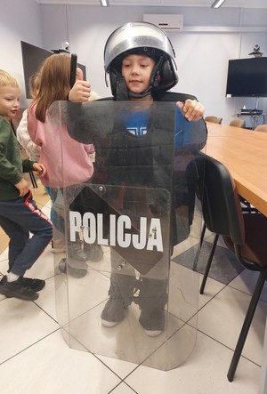 Dzieci na świetlicy Komedy oglądają i przemierzają sprzęt i wyposażenie policjantów