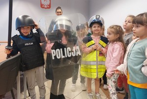 Dzieci na świetlicy Komedy oglądają i przemierzają sprzęt i wyposażenie policjantów