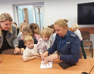 Policjantka pobiera odciski palców przedszkolakom