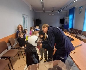 Dzieci oglądają i przymierzają sprzęt wykorzystywane podczas codziennej służby policjantów