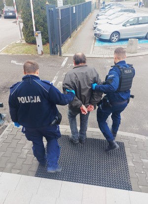 Policjanci podczas doprowadzania osoby zatrzymanej