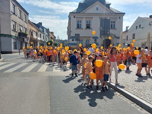 Przemarsz dzieci z Przeworskich szkół ulicami miasta z pomarańczowymi balonikami