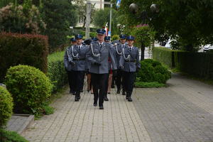 policjanci maszerują w szyku w umundurowaniu galowym