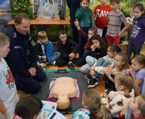 Dziecko wykonuje pod okiem policjanci udzielanie pierwszej pomocy
