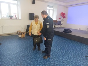 Funkcjonariusz zaprosił na środek seniorkę z torebką i pokazał jak nie dać sobie ukraść z torebki wartościowych przedmiotów ii w jaki sposób złodziej to robi