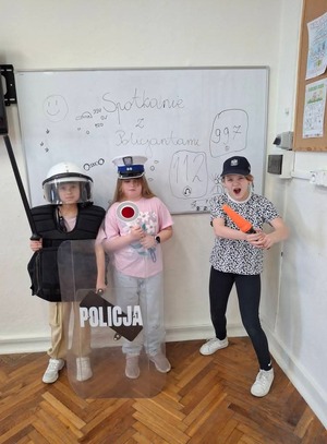 Dzieci mierzą elementy umundurowania funkcjonariuszy