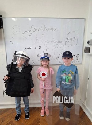 Dzieci mierzą elementy umundurowania funkcjonariuszy
