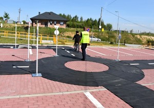 Uczestnicy turnieju podczas jazdy na torze ze znakami drogowymi