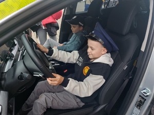 Dzieci oglądają od środka radiowóz policyjny
