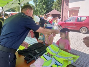 Dzieci mierzą sprzęt policjantów oraz siedzą w radiowozie