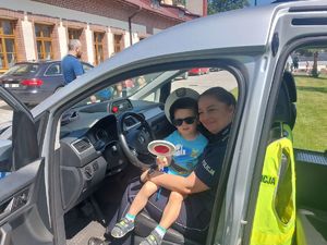 Dzieci mierzą sprzęt policjantów oraz siedzą w radiowozie