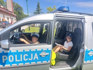 Dzieci mierzą sprzęt policjantów oraz siedzą w radiowozie