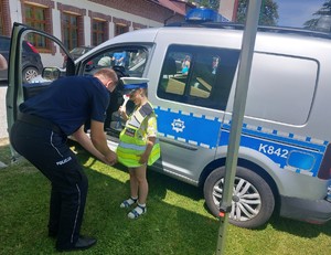 Dzieci mierzą sprzęt policjantów oraz siedzą w radiowozie