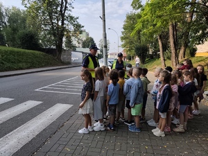 dzieci uczą się przepisów ruchu drogowego i prawidłowego przejścia przez przejście dla pieszych