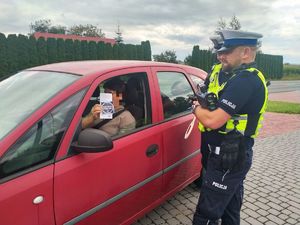 Policjanci podczas działań rozdają naklejki i broszury dotyczące akcji Mistrzu zwolnij