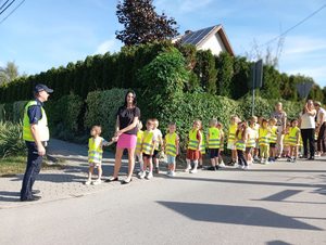 Policjant pokazuje dzieciom jak bezpiecznie przejść przez jezdnię