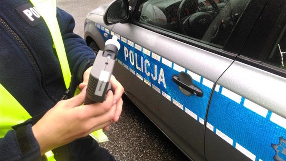 Policjant trzyma w ręce alcosensor