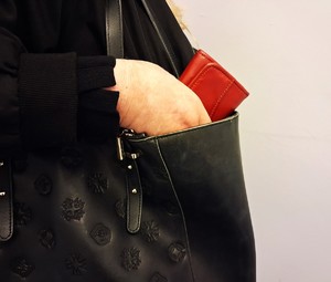 Reka z portfelem trzymanym w torebce