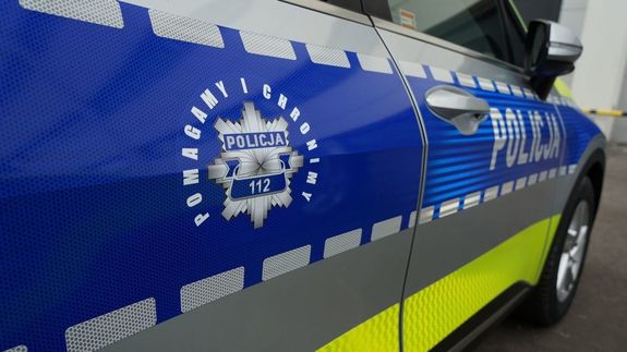 Zdjęcie boku radiowozu z napisem policja