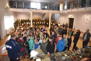 Policjant podczas pokazu mundurów wojskowych i profilaktyki z młodzież