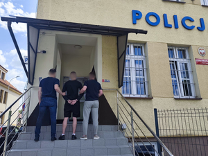Policjanci prowadzą zatrzymanego mężczyznę