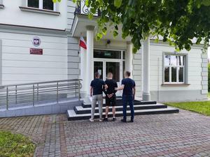 Policjanci prowadzą zatrzymanego mężczyznę