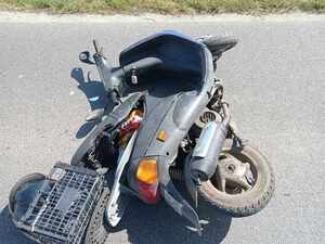 Miejsce zdarzenia drogowego na drodze leży motorower